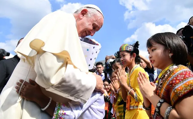Pope Francis (L) is welcomed by children dressed in traditional clothes as he arrives at Yangon International Airport in Yangon, Myanmar, 27 November 2017. Pope Francis' visit in Myanmar and Bangladesh runs from 27 November to 02 December 2017. (Photo by Ettore Ferrari/EPA/EFE)
