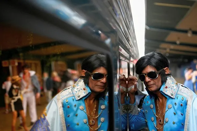 An Elvis Presley impersonator leans against the Elvis Express train at Sydney Central Railway Station before departing for the Parkes Elvis Festival, in Sydney, Australia on January 5, 2023. (Photo by Jaimi Joy/Reuters)
