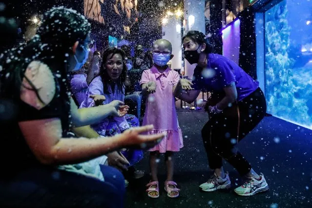 A “Wish Child” (C) celebrates with her parents during a charity event by Make-A-Wish Malaysia organization and Aquaria KLCC at Aquaria KLCC aquarium in Kuala Lumpur, Malaysia, 30 November 2022. Aquaria KLCC joined together with Make-A-Wish Malaysia organization to help a “Wish Child” accompanied by her parents, enjoy the Underwater Santa & Elf Christmas performance by the professional dive team. (Photo by Fazry Ismail/EPA/EFE/Rex Features/Shutterstock)