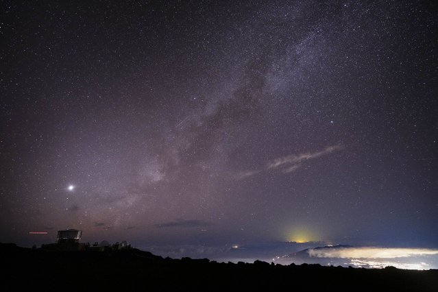 The Milky Way is seen over the Haleakala Observatory and the lights of Kahului, at right, Saturday, November 23, 2024 at the summit of Haleakala National Park near Kula, Hawaii. (Photo by Lindsey Wasson/AP Photo)