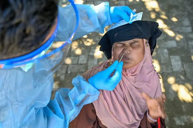 A Rohingya refugee has a swab sample taken to be tested for the Covid-19 coronavirus at a temporary shelter in Ladong, Indonesia's Aceh province on January 9, 2023. Thousands of the mostly Muslim Rohingya, heavily persecuted in Myanmar, risk their lives each year on long and expensive sea journeys – often in poor-quality boats -–in an attempt to reach Malaysia or Indonesia. (Photo by Chaideer Mahyuddin/AFP Photo)