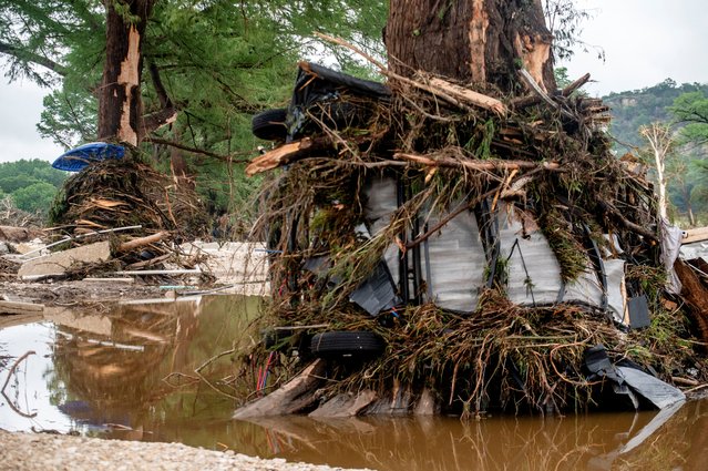 A trailer is wrapped around a tree after deadly flooding in Ingram, Texas, on July 5, 2025. (Photo by Sergio Flores/Reuters)