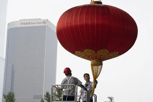 Workers prepare a giant lantern ahead of the Oct. 1 National Day holidays in Beijing on Monday, September 28, 2020. (Photo by Ng Han Guan/AP Photo)