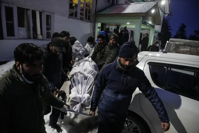 Indian policemen and paramedic staff carry the body of a Polish skier who were killed in an avalanche outside a local hospital in Tangmarg, 45 kilometers from Srinagar, in Indian controlled Kashmir, Wednesday, February 1, 2023. An avalanche at a Himalayan ski resort in Indian-controlled Kashmir Wednesday killed two foreign skiers while 21 others were rescued, police said. (Photo by Mukhtar Khan/AP Photo)