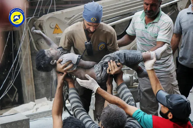 This Tuesday, September 27, 2016 photo, provided by the Syrian Civil Defense group known as the White Helmets, shows a Civil Defense worker carrying the body of a child after airstrikes hit al-Shaar neighborhood in Aleppo, Syria. Pope Francis has decried the assault on the Syrian city of Aleppo, saying those responsible for the bombing must answer to God. (Photo by Syrian Civil Defense White Helmets via AP Photo)