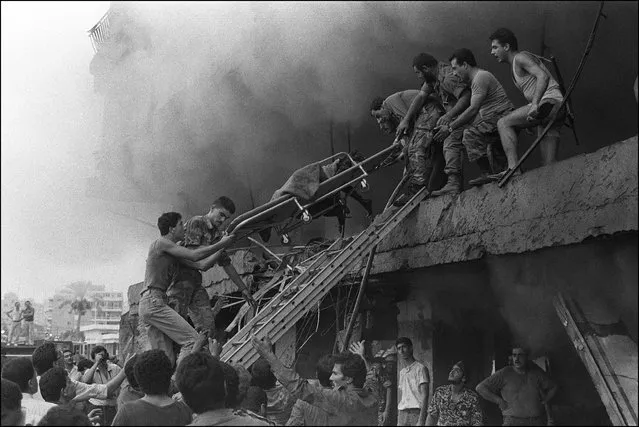 Rescuers extract on a strecher a burned body from the first floor of a building destroyed 17 August 1985 in the Christian east Beirut after the explosion of a car bomb which brought down several buildings, killing 50 people and wounding 120. The bomb, estimated at 200 kilos (440 pounds), blew up as the car was being driven by a suicide bomber through a crowded street. The Lebanese civil war broke out in April 1975 when Palestinians made an attack on Maronit Christian Phalangists. Christian militia, backed by Christian Kataeb (Phalangist) party, massacred the passengers of a bus, who were mainly Palestinians. Intercommunal fighting between Christians and Muslims quickly spread. (Photo by Maher Attar/AFP Photo)
