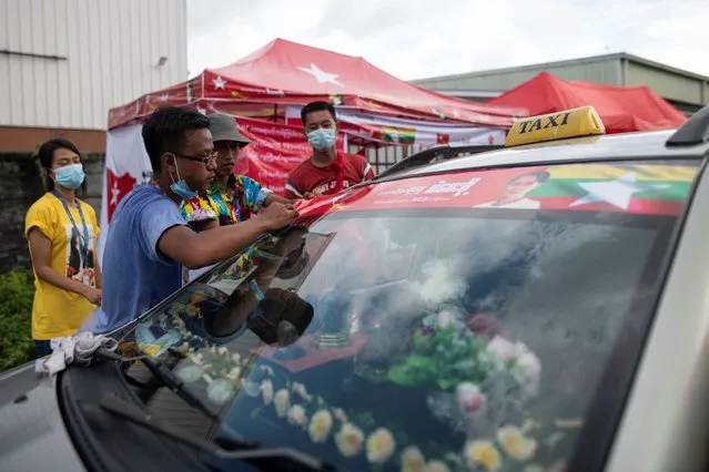 A volunteer puts a sticker of Myanmar State Counselor Aung San Suu Kyi on a car bonnet in Yangon, Myanmar on September 12, 2020. Myanmar will hold its general election on November 8. (Photo by Shwe Paw Mya Tin/NurPhoto via Getty Images)