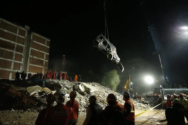Members of rescue services work on the debris of a collapsed building in Izmir, Turkey, Sunday, November 1, 2020. Rescue teams continue ploughing through concrete blocs and debris of collapsed buildings in Turkey's third largest city in search of survivors of a powerful earthquake that struck Turkey's Aegean coast and north of the Greek island of Samos, Friday Oct. 30, killing dozens Hundreds of others were injured. (Photo by Emrah Gurel/AP Photo)