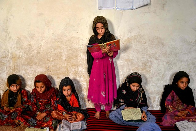 An Afghan girl reads a religious book at a madrassa, or an Islamic school, at Navai village in the Spin Boldak district of Kandahar on August 23, 2025. (Photo by Sanaullah Seiam/AFP Photo)