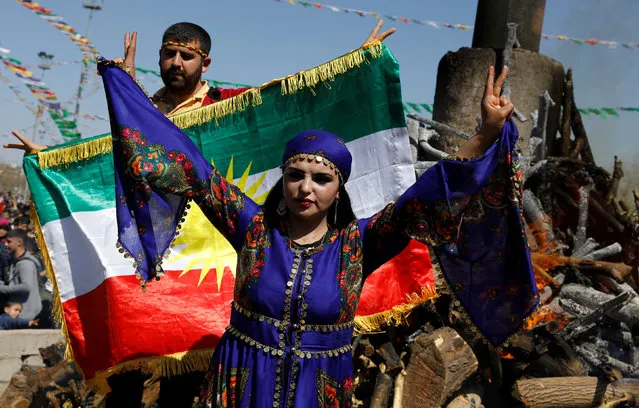 People gesture during a gathering celebrating Newroz in Diyarbakir, Turkey on March 21, 2018. (Photo by Umit Bektas/Reuters)