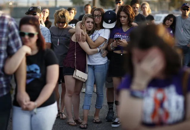 People comfort each other during a vigil for victims and survivors of a mass shooting in Las Vegas, Sunday, April 1, 2018, in Las Vegas. Sunday marked six months since the shooting along the Las Vegas Strip, when over 50 people were killed and hundreds injured. (Photo by John Locher/AP Photo)