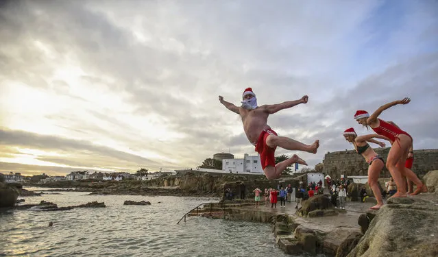 People take part in the annual Christmas Day swim at the Forty Foot bathing spot in Sandycove Dublin, Ireland, Friday December 25, 2020. (Photo by Damien Storan/PA Wire via AP Photo)