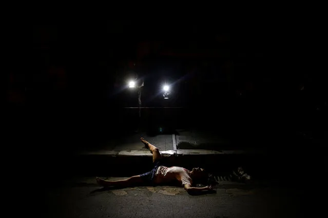 The body of a man killed by unknown gunmen is lit by lights from TV cameras in Manila, Philippines early October 24, 2016. (Photo by Damir Sagolj/Reuters)