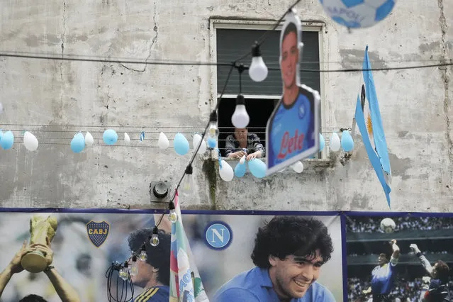 A woman retrieves deflated balloons from her window adorned with the colours of the Napoli soccer team in Naples, Italy, Monday, May 1, 2023. Napoli wasted what seemed like a perfect chance to seal the Serie A title at home inside the Stadio Diego Armando Maradona on a holiday weekend afternoon in a 1-1 draw with regional rival Salernitana on Sunday. The result disappointed legions of Napoli fans who had already started celebrating in anticipation of the championship. (Photo by Gregorio Borgia/AP Photo)