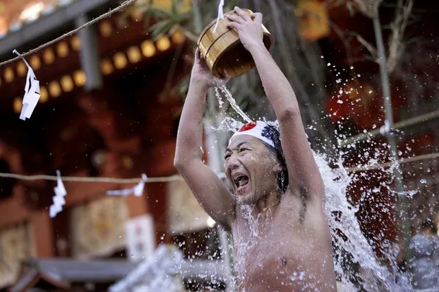 A half-naked shrine parishioner using a wooden tub pours cold water onto himself during an annual cold-endurance festival at the Kanda Myojin Shinto shrine in Tokyo, Saturday, January 10, 2015. (Photo by Eugene Hoshiko/AP Photo)
