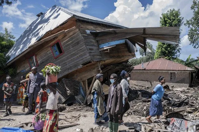 People walk next to a house destroyed by the floods in the village of Nyamukubi, South Kivu province, in Congo, Saturday, May 6, 2023. (Photo by Moses Sawasawa/AP Photo)