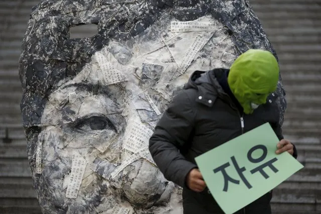 An activist wearing a mask stands in front of giant sculpture depicting South Korean President Park Geun-hye during an anti-government rally in central Seoul, South Korea, December 5, 2015. The sign reads: "Freedom". (Photo by Kim Hong-Ji/Reuters)