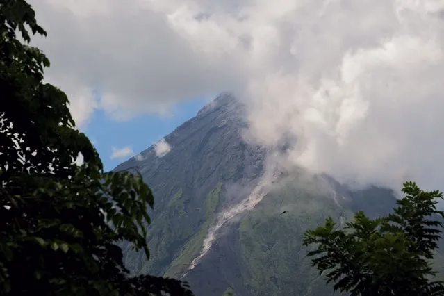 Mayon Volcano spews white smoke as seen from Daraga, Albay province, central Philippines on Thursday June 8, 2023. The Philippine Institute of Volcanology and Seismology raised Thursday the status of Mayon Volcano in Albay to Alert Level 3 due to “increased tendency towards a hazardous eruption”. (Photo by John Michael Magdasoc/AP Photo)