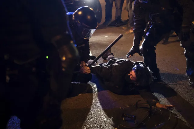 A demonstrator is detained by police during clashes following a protest condemning the arrest of rap singer Pablo Hasél in Barcelona, Spain, Saturday, February 27, 2021. (Photo by Felipe Dana/AP Photo)