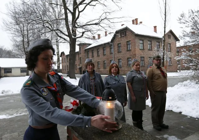 Members of Polish Scouting Association from Canada and U.K. place a lit candle at block 15 in the former Nazi German concentration and extermination camp Auschwitz in Oswiecim January 26, 2015. Ceremonies to mark the 70th anniversary of the liberation of the camp will take place on January 27, with some 300 former Auschwitz prisoners taking part in the commemoration event. (Photo by Laszlo Balogh/Reuters)