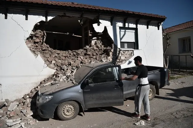 A man tends to hisd car after a building partially collapsed on it in the village of Damasi, near the town of Tyrnavos, after a strong 6,3-magnitude earthquake hit the Greek central region of Thessaly. A strong 6.3-magnitude earthquake hit central Greece on March 3, damaging several buildings, including schools, and prompting residents near the epicentre to rush into the streets. According to the Athens observatory, the epicentre of the quake was 21 kilometres (13 miles) south of the town of Elassona, near Larissa and was eight kilometres deep. (Photo by Sakis Mitrolidis/AFP Photo)