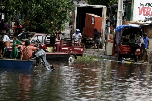 Paraguayans remove their belongings from their flooded houses near the Paraguay river in Asuncion, December 20, 2015. (Photo by Jorge Adorno/Reuters)