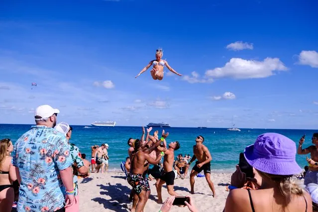 A college athlete is thrown in the air by a group of men on the beach to celebrate spring break in Fort Lauderdale, Florida, March 5, 2021. (Photo by Marco Bello/Reuters)