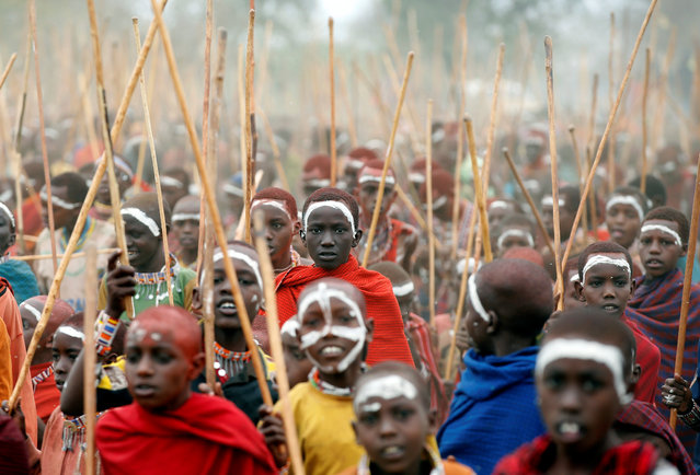 Maasai children hold sticks as they gather for an initiation into an age group ceremony near the town of Bisil, Kajiado county, Kenya on August 23, 2018. (Photo by Baz Ratner/Reuters)