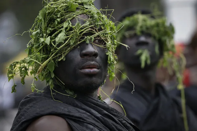 Guards of a Ghanaian chief wear black and plants on their heads, a tradition when going to a funeral, and queue outside to pay their respects as the coffin of former U.N. Secretary-General Kofi Annan lies in state at the Accra International Conference Center in Ghana Wednesday, September 12, 2018. Ghanaians are paying their respects to Annan, who died in August in Switzerland at age 80, ahead of Thursday's state funeral. (Photo by Sunday Alamba/AP Photo)