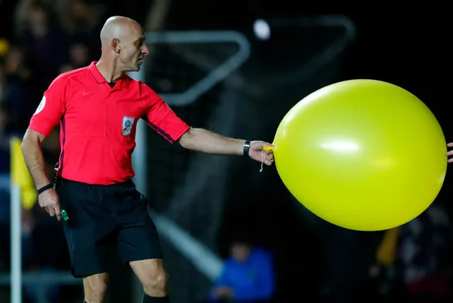 Referee Roger East removes a balloon from the pitch during the English League Cup soccer match between Oxford United and Manchester City at the Kassam Stadium in Oxford, England, Tuesday, September 25, 2018. (Photo by Eddie Keogh/Reuters)