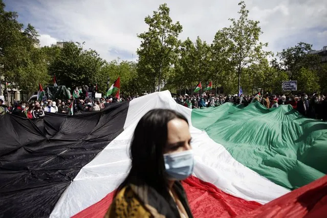 Protesters hold a giant Palestinian flag in Paris, Saturday, May 22, 2021, as they take part in a rally supporting Palestinians. Egyptian mediators held talks Saturday to firm up an Israel-Hamas cease-fire as Palestinians in the Hamas-ruled Gaza Strip began to assess the damage from 11 days of intense Israeli bombardment.Supporters of the Palestinians. (Photo by Thibault Camus/AP Photo)