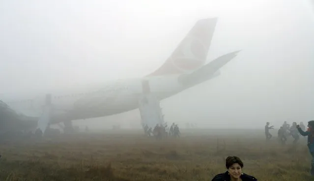 Passengers exit from a Turkish Airlines plane soon after it overshot from the runway in Kathmandu March 4, 2015. According to local media, all passengers and crew members of the flight were rescued. REUTERS/Dikesh Malhotra