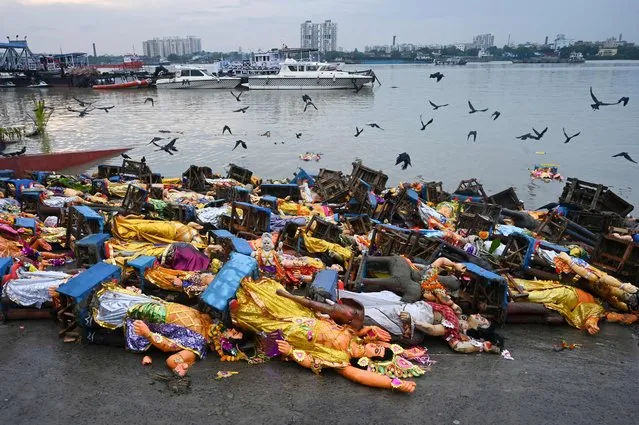 Retrieved idols of Lord Vishwakarma are seen pilled up on the banks of the Ganges River after being immersed during the Vishwakarma festival in Kolkata on September 20, 2023. (Photo by Dibyangshu Sarkar/AFP Photo)