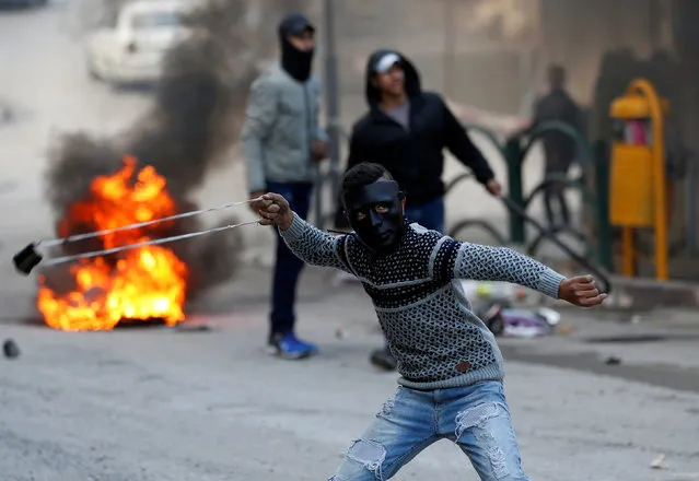 A Palestinian protester hurls stones at Israeli troops during clashes in Hebron in the occupied West Bank October 26, 2018. (Photo by Mussa Qawasma/Reuters)