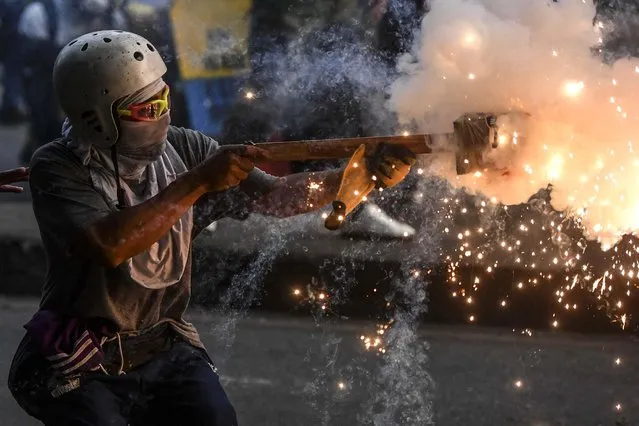 Demonstrators clash with Riot police during a new protest against the government of Colombian President Ivan Duque, in Medellin on May 19, 2021. The protest movement in Colombia took to the streets again on Wednesday before sitting down to negotiate with the government an eventual solution to the crisis that erupted on April 28, and fuelled by police abuses partially recognized by President Ivan Duque. (Photo by Joaquin Sarmiento/AFP Photo)
