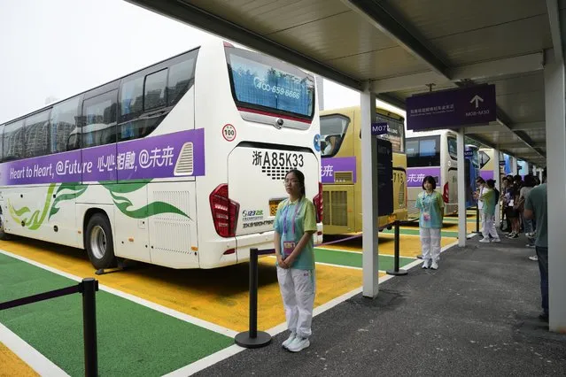 Chinese volunteers stand at a shuttle bus hub at the 19th Asian Games in Hangzhou, China, Tuesday, September 26, 2023. Signs around Hangzhou billed the city as a “paradise on earth” while China adopted the motto “heart to heart” for the games, which attract feature some 12,000 competitors, more than the summer Olympics, from across Asia and the Middle East. (Photo by Aaron Favila/AP Photo)