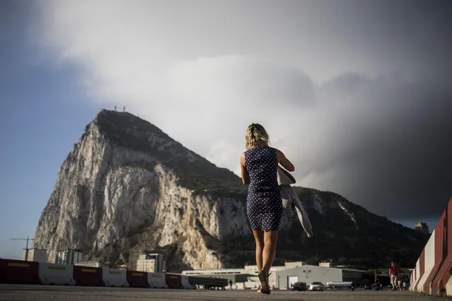 Backdropped by the Gibraltar rock, a woman crosses the Gibraltar airport runway, Thursday, June, 24, 2021. Gibraltar is holding a referendum on whether to introduce exceptions to the British territory's ban on abortion. Abortion is illegal in Gibraltar, unless it is needed to save the mother's life. Abortion is legally classified as “child destruction” and is punishable by up to life in prison. (Photo by Javier Fergo/AP Photo)