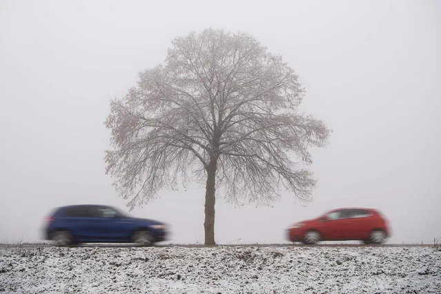 Cars drive on a country road through the snowy landscape in Grabenstetten near Reutlingen, southwestern Germany, on November 27, 2018. (Photo by Sebastian Gollnow/DPA via AFP Photo)