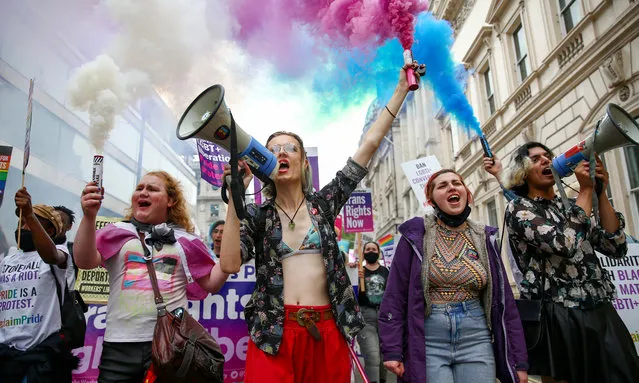 Demonstrators hold smoke flares during a Reclaim Pride March on July 24, 2021 in London, England. The march replaces the Pride in London parade which has been postponed. (Photo by Hollie Adams/Getty Images)