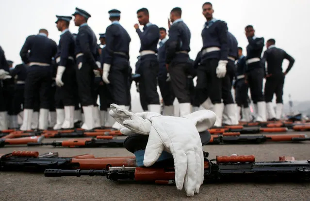 Indian Air Force soldiers stand among guns and gloves laid on the road during a break at the rehearsal for the Republic Day parade on a cold winter morning in New Delhi, India, December 26, 2018. (Photo by Adnan Abidi/Reuters)