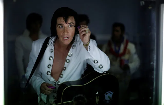 Elvis Presley tribute artist Stephen Fletcher puts on eye make-up in the mirror before competing in a singing contest at the 25th annual Parkes Elvis Festival in the rural Australian town of Parkes, west of Sydney, Australia January 13, 2017. (Photo by Jason Reed/Reuters)