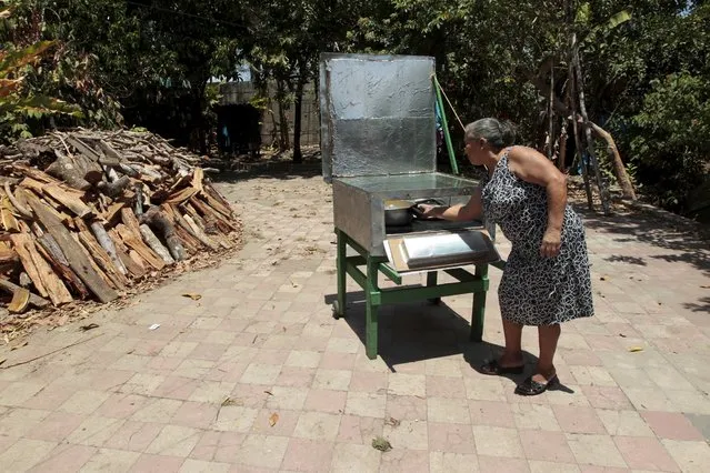 Carmen Selva, who is a member of the Solar Project Foundation for Nicaraguan Women (FUPROSOMUNIC), prepares food in a solar cooker at Diriomo town April 15, 2015. (Photo by Oswaldo Rivas/Reuters)