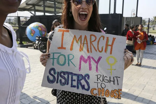 Activist Sarah Annay Williamson holds a placard and shouts slogan during the Women's March rally in Kolkata, India, Saturday, January 21, 2017. The march was held in solidarity with the Women's March on Washington, advocating women's rights and opposing Donald Trump's presidency. (Photo by Bikas Das/AP Photo)