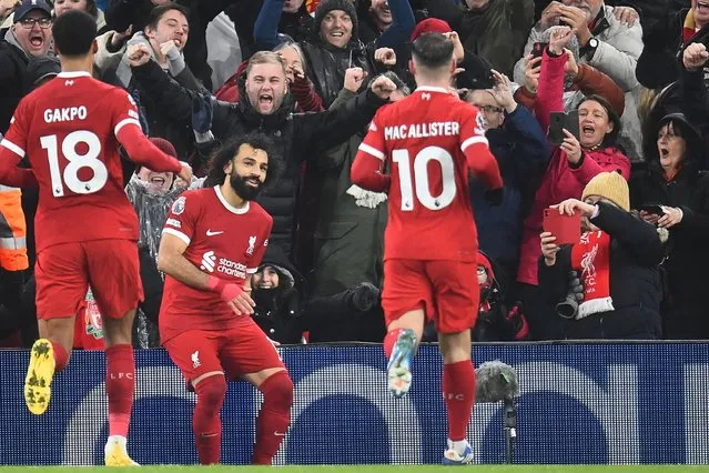 Liverpool's Egyptian striker #11 Mohamed Salah (2L) celebrates after scoring their fourth goal from the penalty spot during the English Premier League football match between Liverpool and Newcastle United at Anfield in Liverpool, north west England on January 1, 2024. (Photo by Peter Powell/AFP Photo)