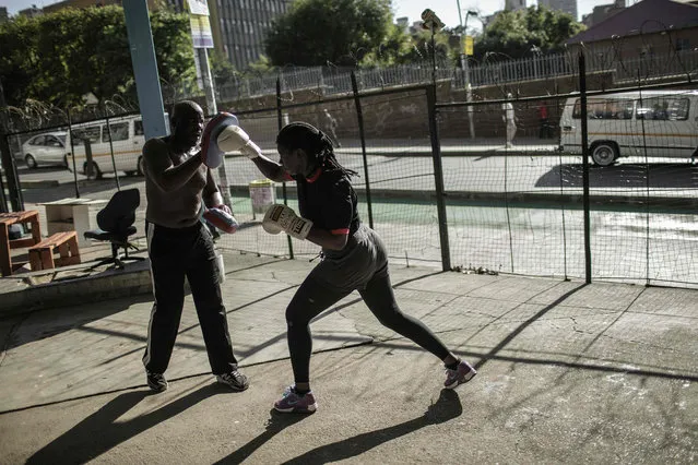 Boxing trainer George Khosi (L) spars with amateur fighter Selina Mabunda (R) at the Hillbrow boxing club on March 2, 2016, in Johannesburg. The Hillbrow boxing club used to be a petrol station before being turned into a boxing gym in the dilapidated neighbourhood of Hillbrow. (Photo by Gianluigi Guercia/AFP Photo)