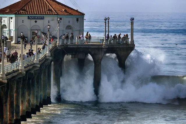 People watch as turbulent surf pounds the side of the pier in Manhattan Beach, Calif. on Thursday, December 28, 2023. APhoto by Richard Vogel/P Photo)