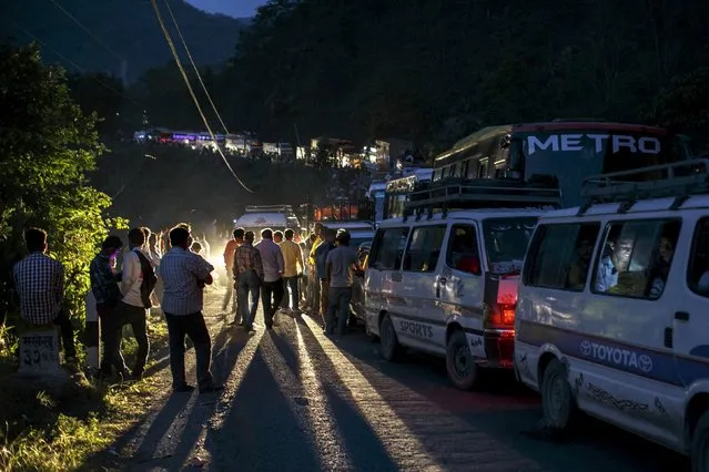 People gather on a road as traffic is affected by a landslide caused by an earthquake, in Kurintar, Nepal April 27, 2015. (Photo by Athit Perawongmetha/Reuters)