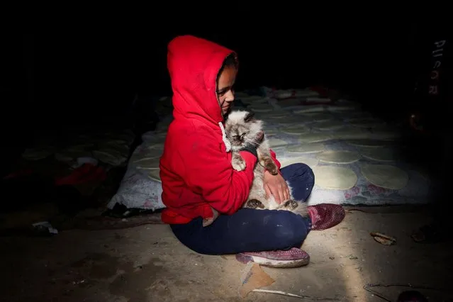 A child holds a cat as displaced Palestinians, who fled their houses due to Israeli strikes, shelter at a tent camp, amid the ongoing conflict between Israel and the Palestinian Islamist group Hamas, in Rafah in the southern Gaza Strip on January 18, 2024. (Photo by Ibraheem Abu Mustafa/Reuters)