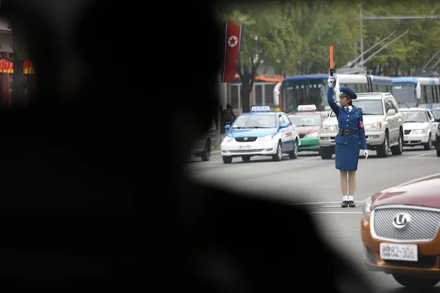 In this October 8, 2015, photo, a North Korean traffic police officer directs vehicles during lunch hour in Pyongyang, North Korea. The streets of Pyongyang are more crowded than ever, but Pyonghwa Motors, North Korea's only passenger car company, whose sole factory was designed to produce as many as 10,000 cars a year, appears to be stuck in neutral. (Photo by Wong Maye-E/AP Photo)