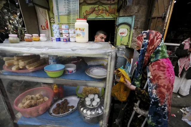 A woman buys food from a roadside stall in Yemen's capital Sanaa March 3, 2016. (Photo by Khaled Abdullah/Reuters)
